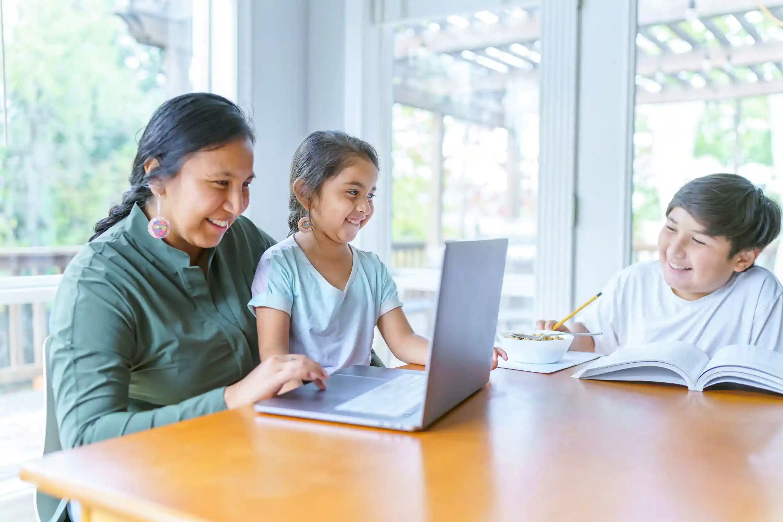 Indigenous family sitting at the dining table with a laptop