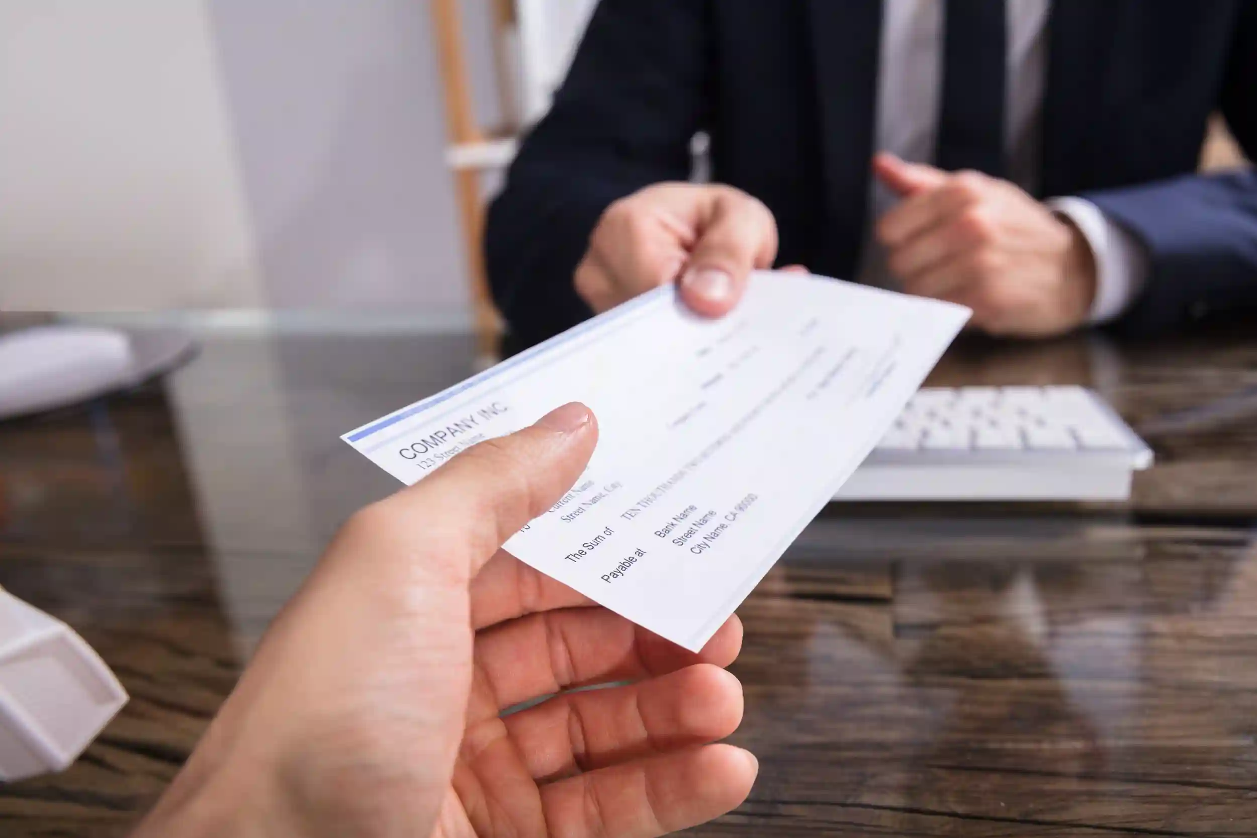 Manager handing an employee a paycheck.