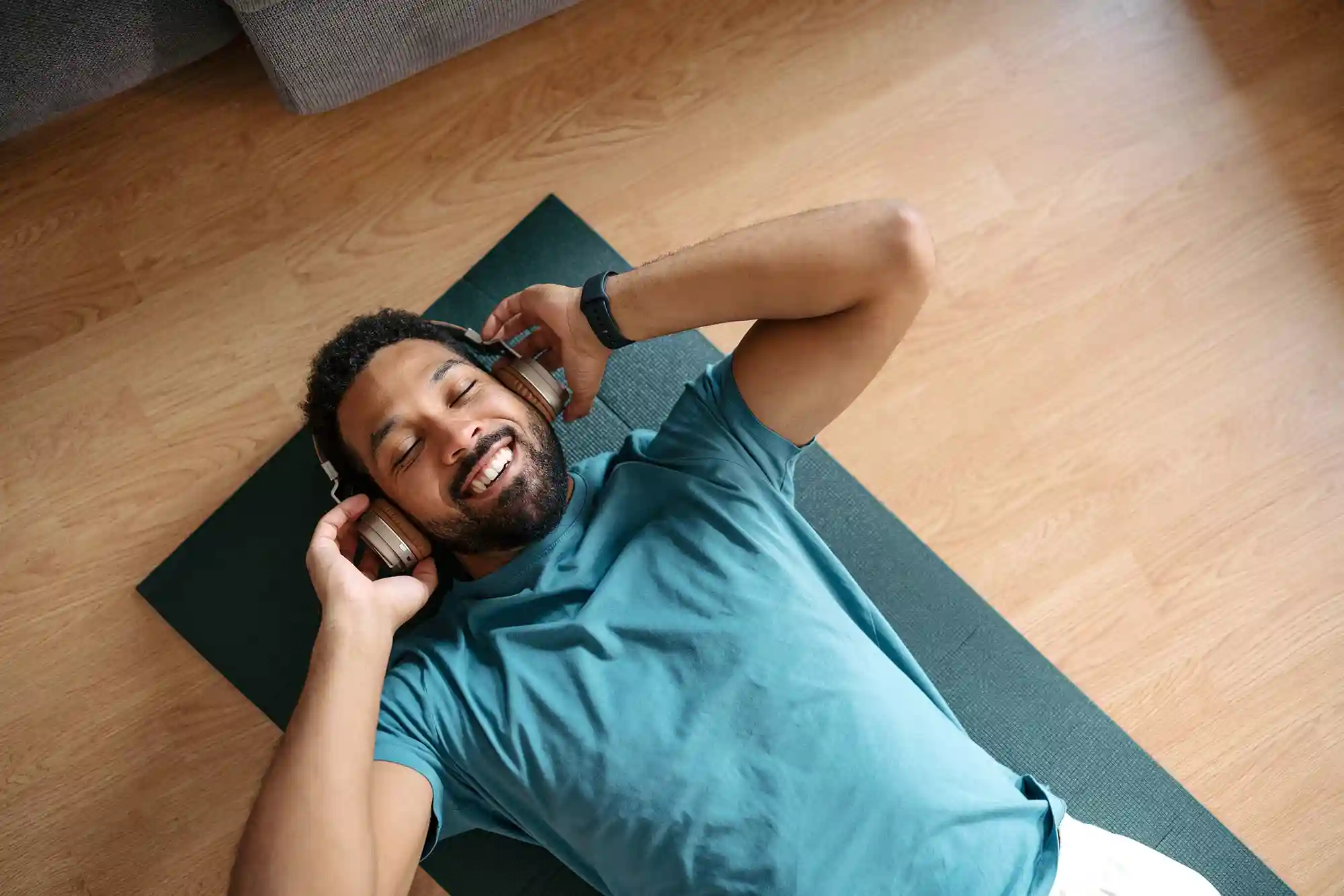 A man enjoys listening to headphones during his workout.
