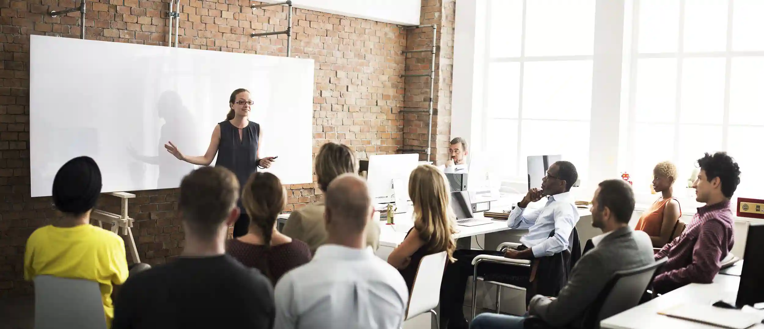 Business meeting in a conference room with a white board.