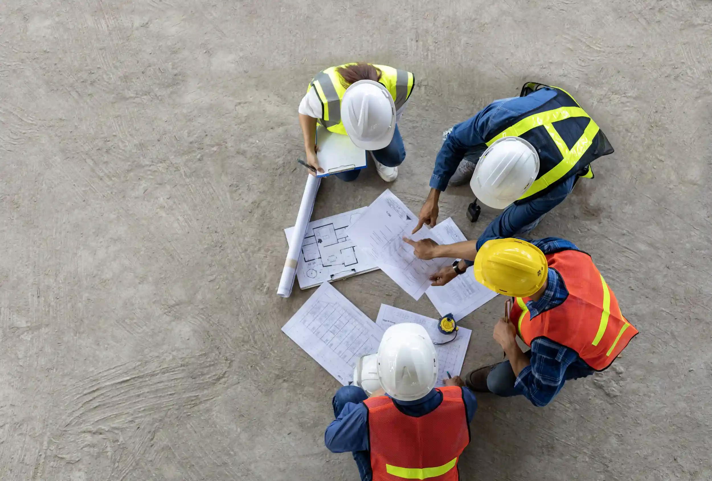 aerial view of construction workers looking at blueprints