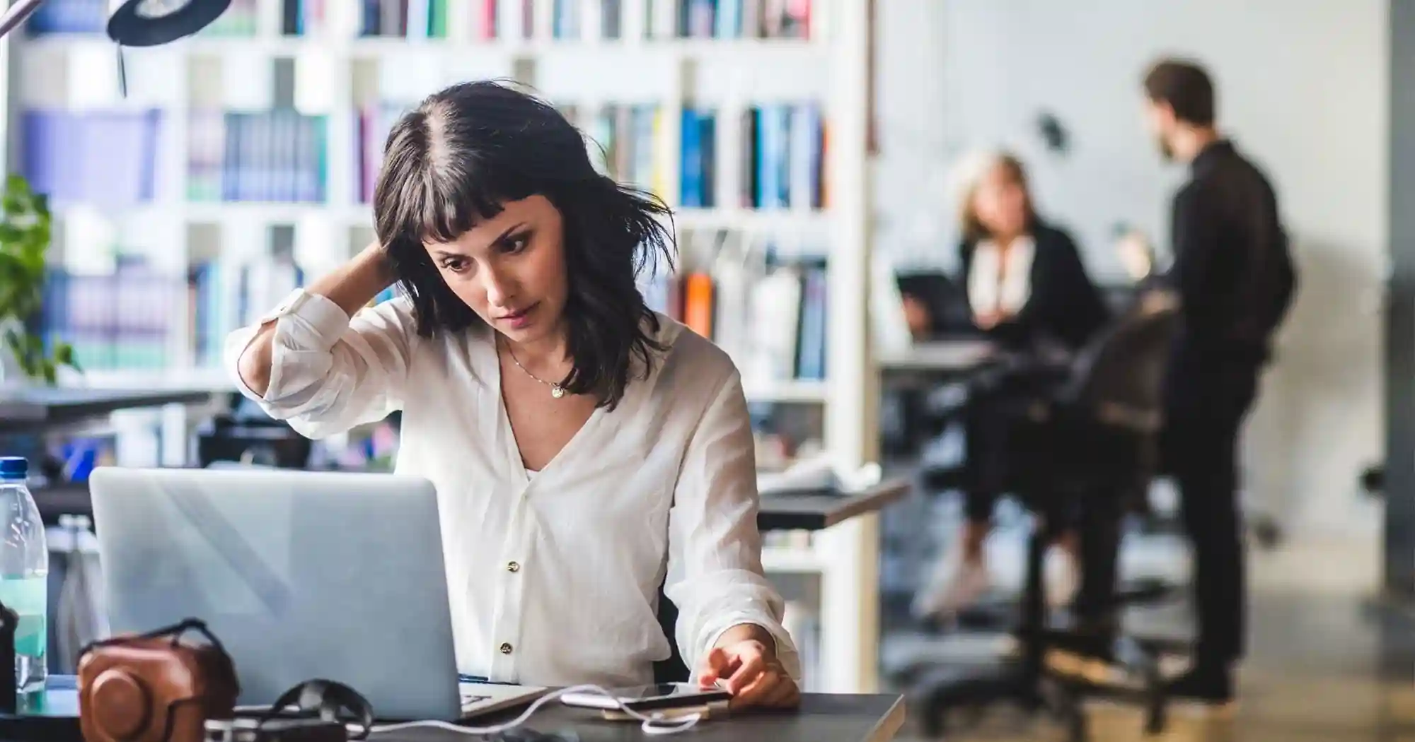 woman scratching her head confused at her computer