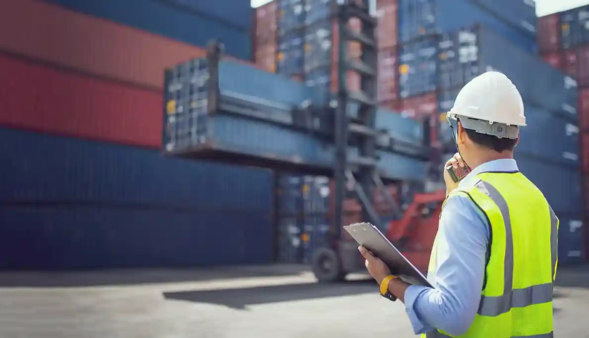 A dock worker carries a clipboard